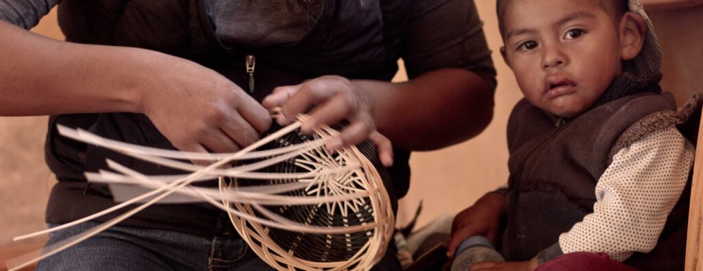 mujer artesana tejiendo canasta artesanal